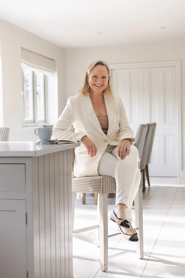 Executive Health & Performance Coach, Ann-Marie sitting at kitchen bar with mug of tea